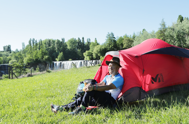 들판에 빨간색 텐트를 치고 앉아 있는 엄홍길대장님 사진